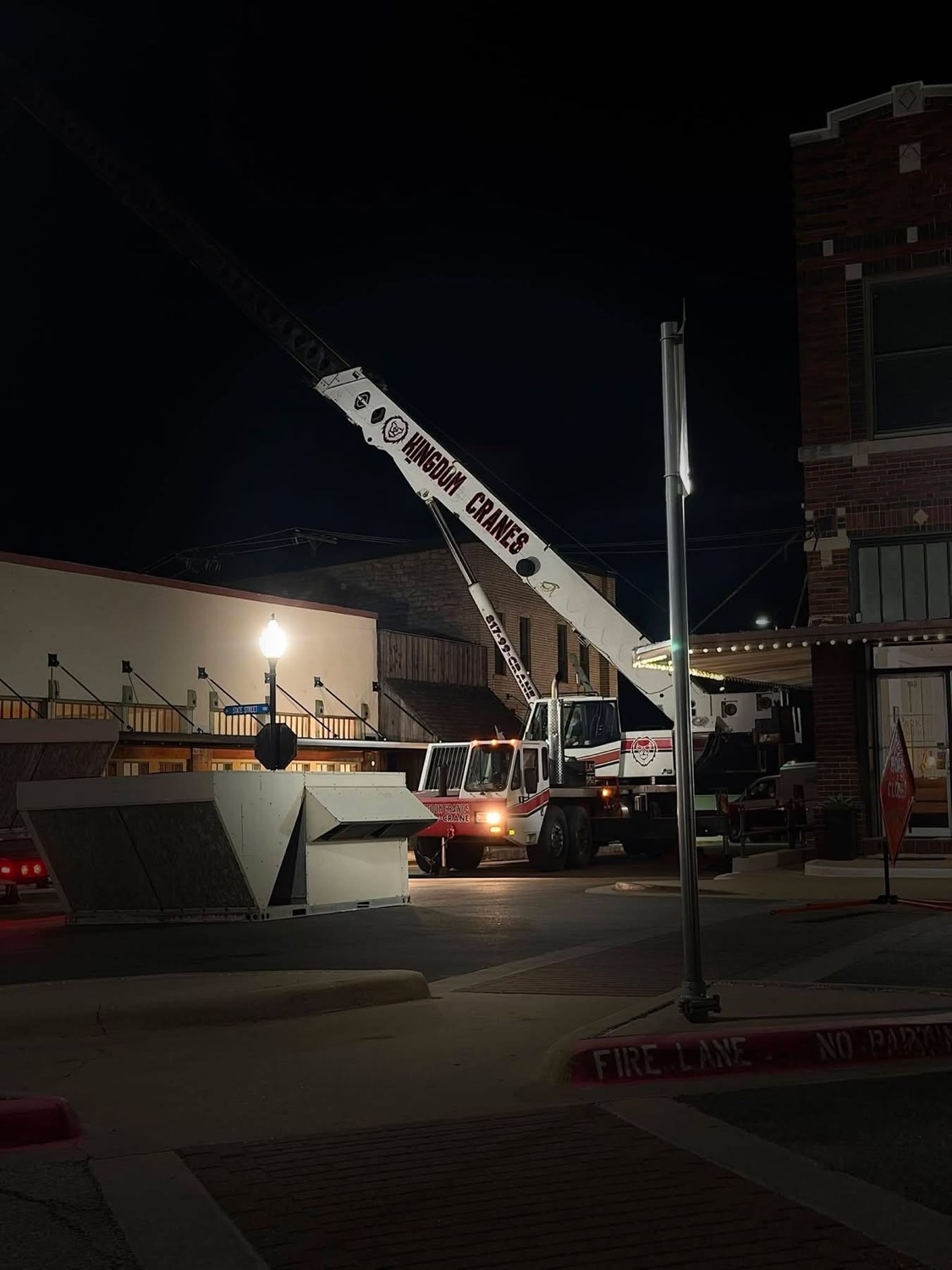 Kingdom Cranes crane performing a nighttime HVAC rooftop unit lift